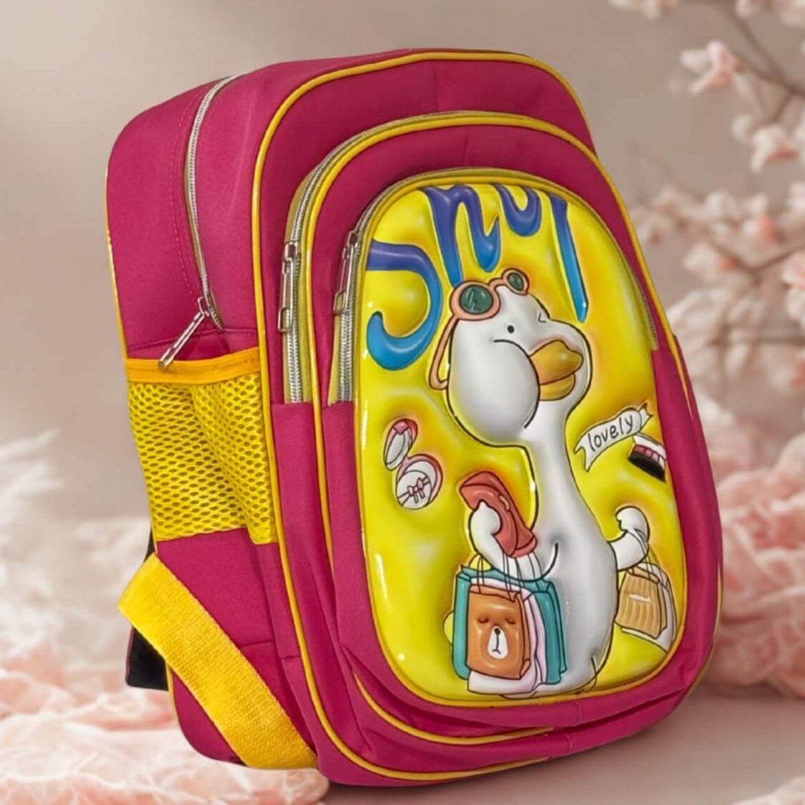 Colorful children's backpack with cartoon character on a soft pink surface